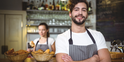 Vriendelijke horecamedewerker achter de bar in een café